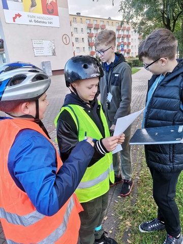 Uczestnicy akcji klimatycznie w Wejherowie w trakcie gry Eko Mobilni na tle bloków Osiedla Kaszubskiego.
