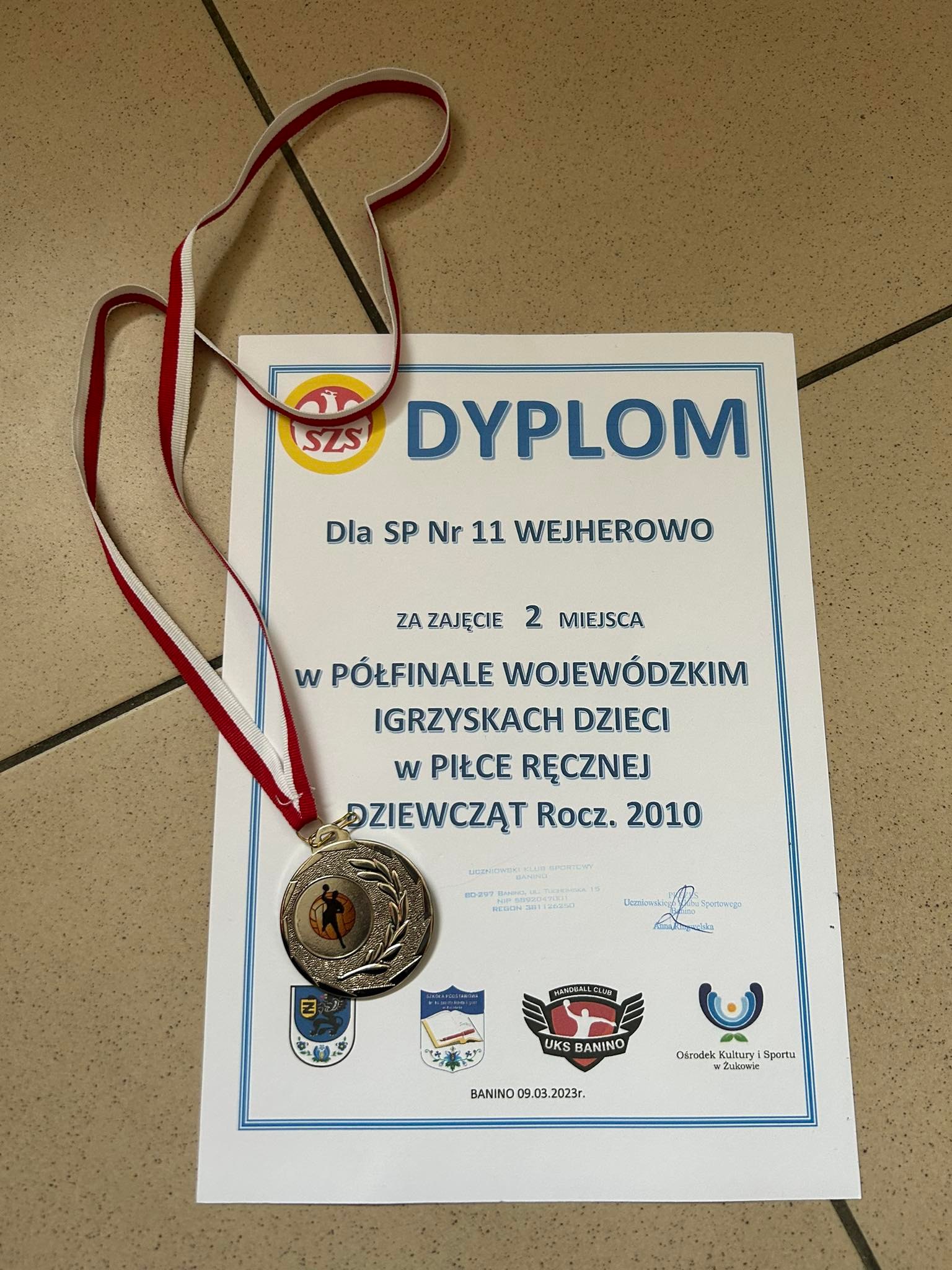 zdjęcie srebrnego medalu i dyplomu za zajęcie II miejsca w półfinałach wojewódzkich w mini piłce ręcznej dziewcząt